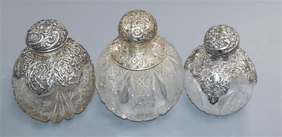 Three assorted late Victorian or Edwardian silver mounted cut glass globular scent bottles, largest 15cm.